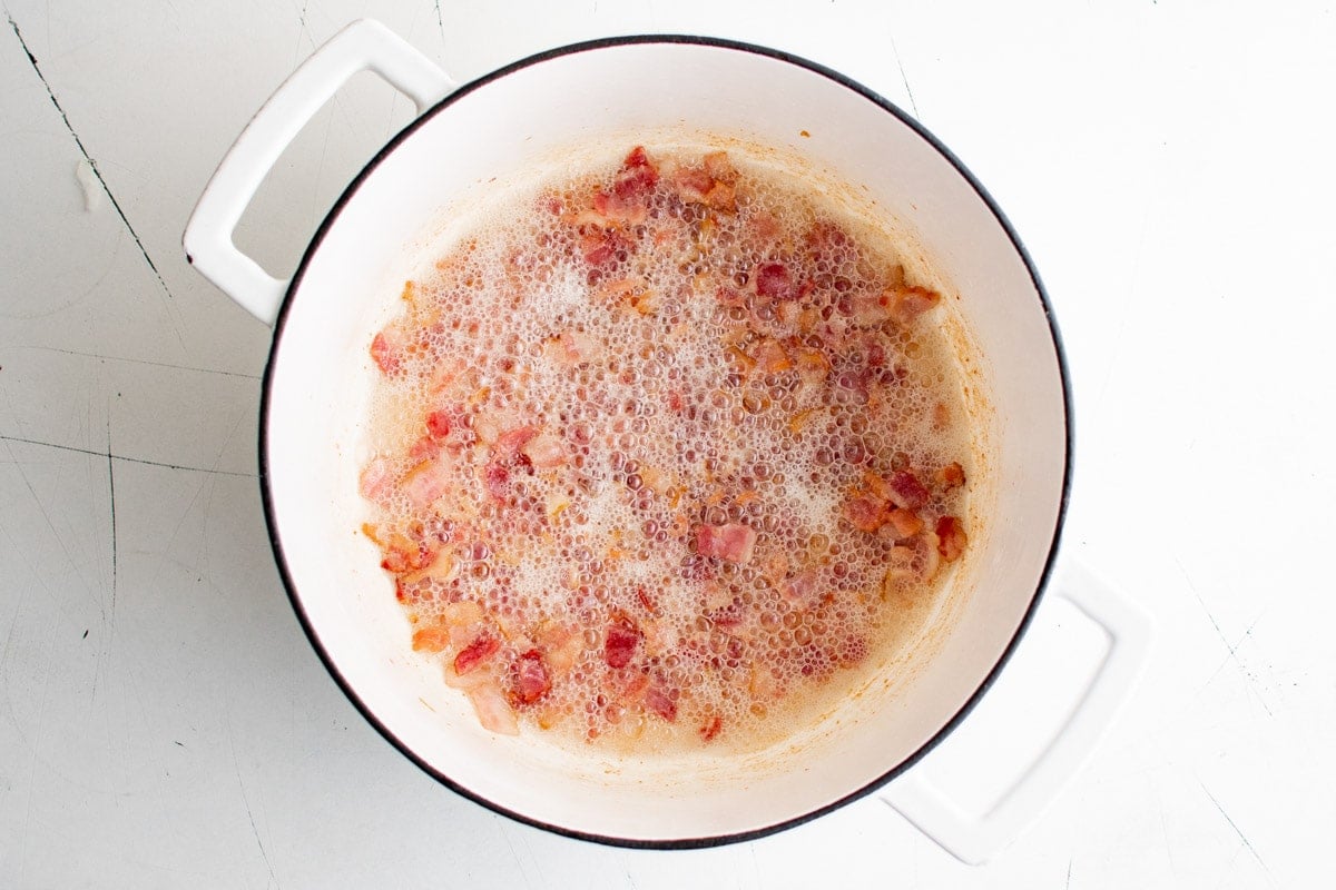 Bacon frying a a deep pot.