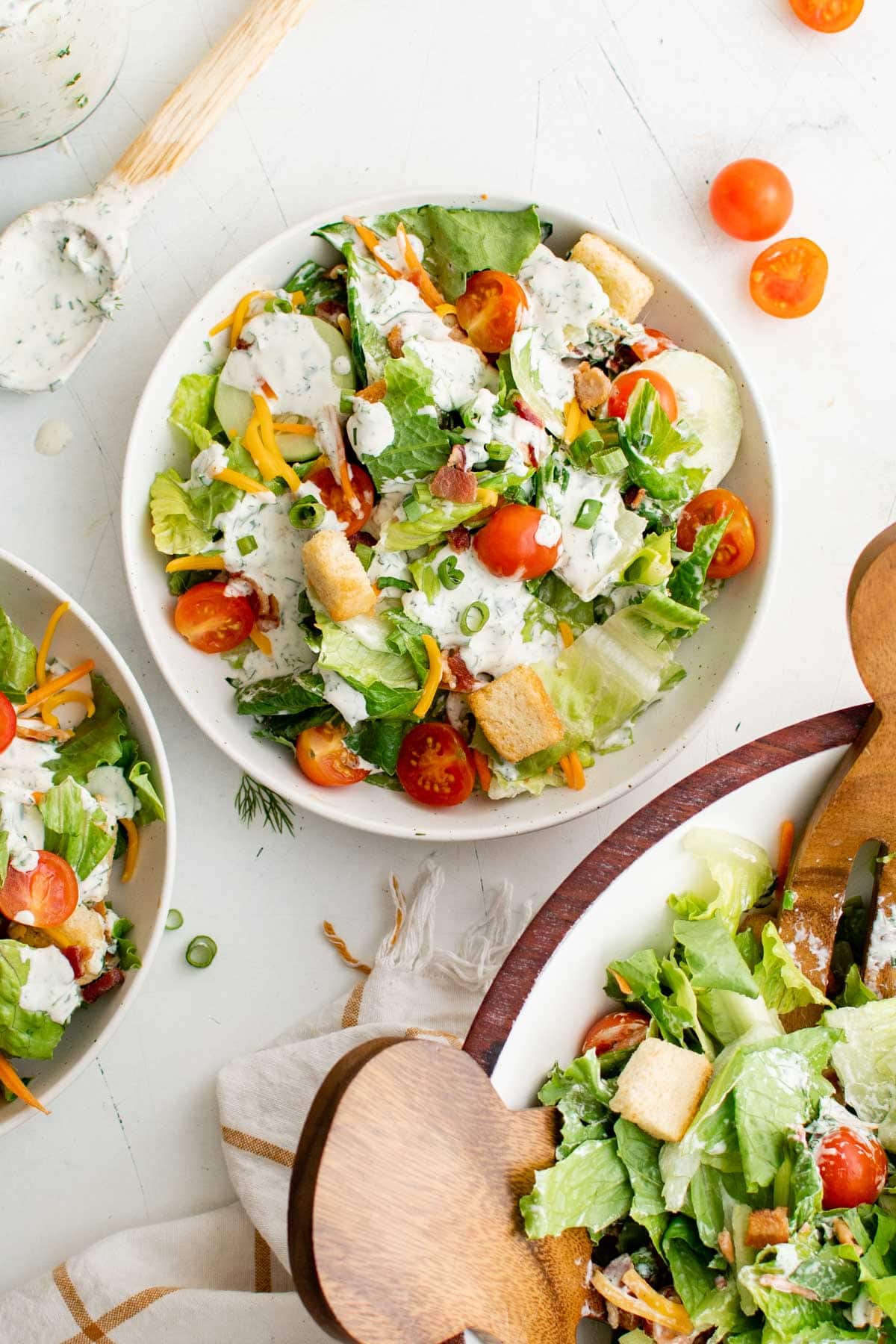 Lettuce in a bowl with tomatoes, carrots, cheese and ranch.