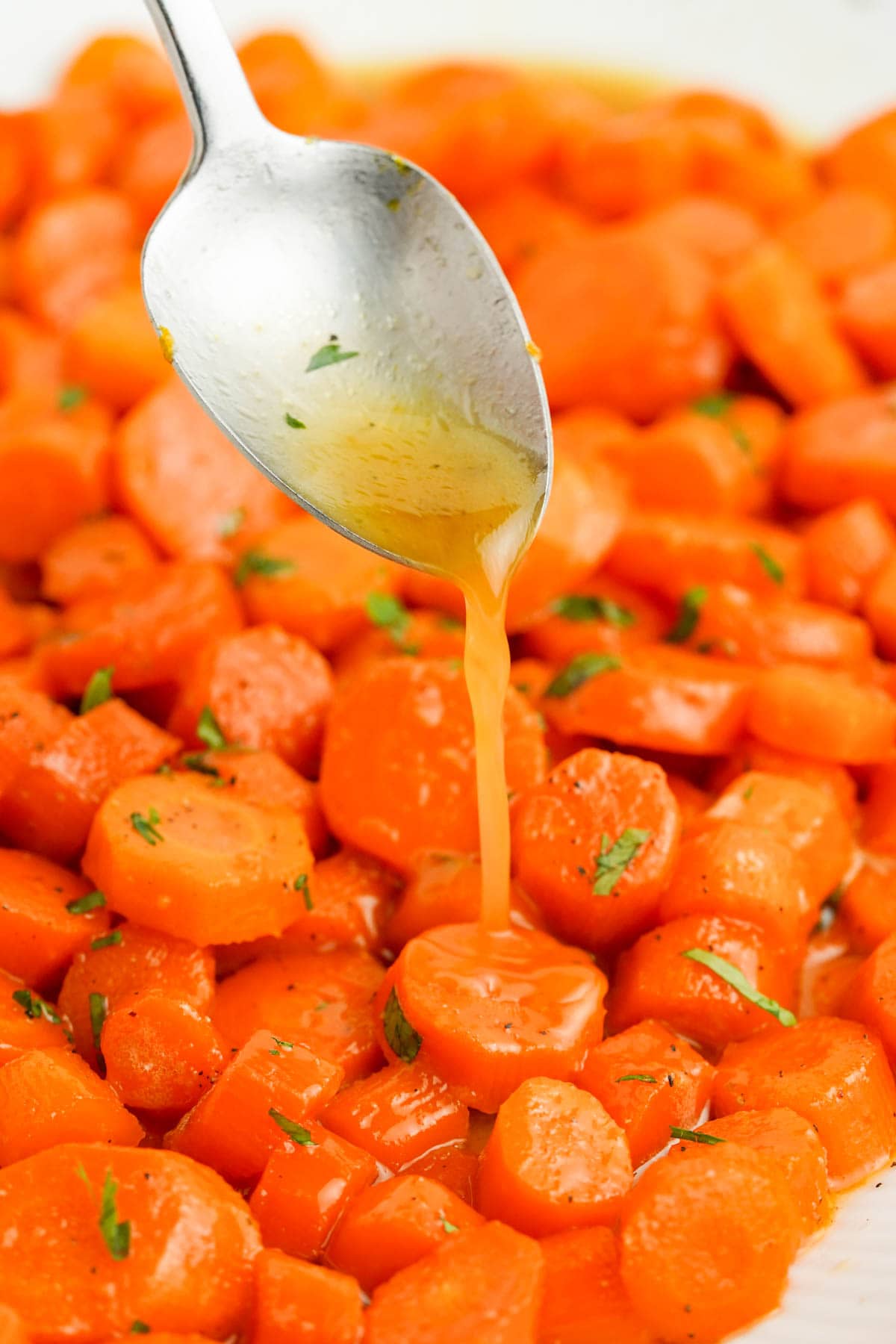 Sliced carrots being drizzled with brown sugar sauce.