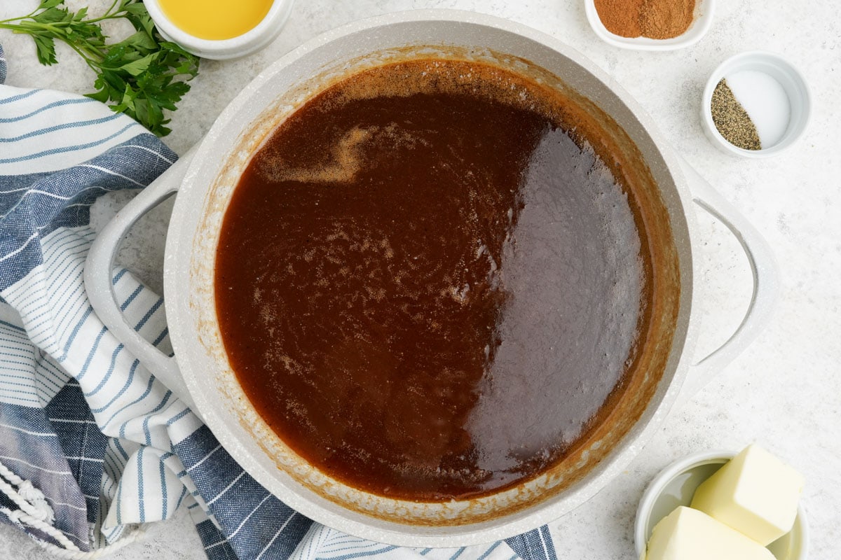 Brown sugar liquid mixture in a large white pot.