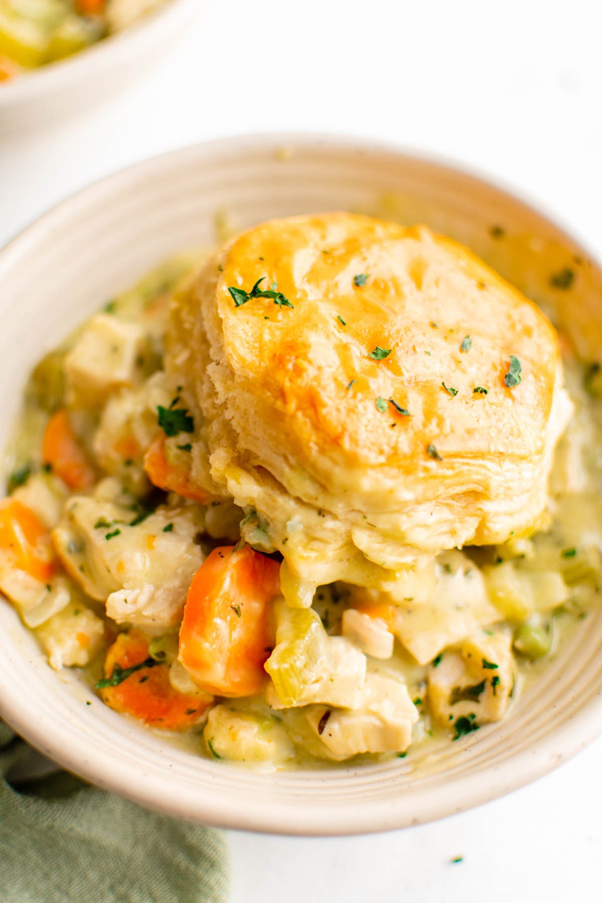 Bowl of chicken pot pie with a biscuit on top. 