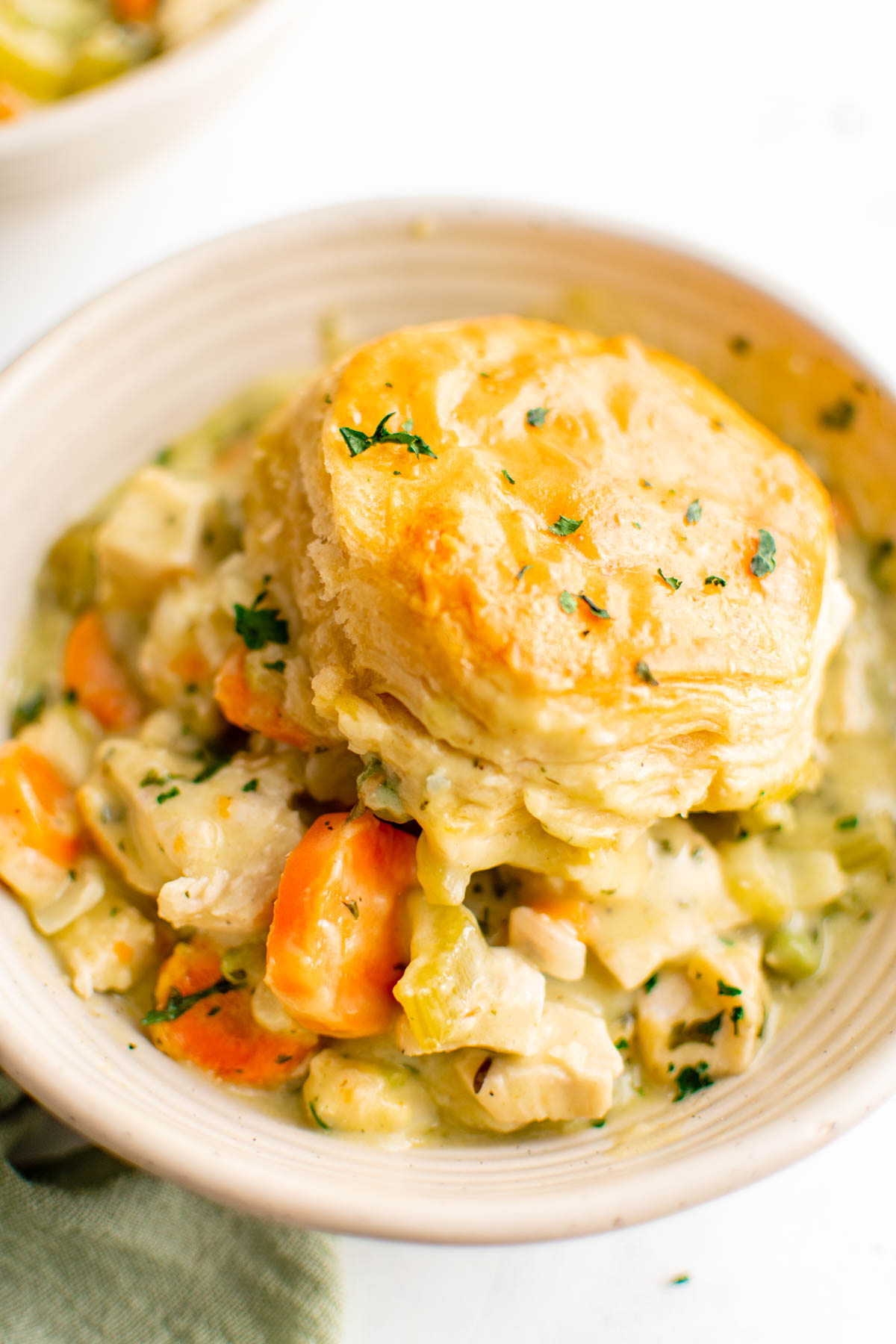Bowl of chicken pot pie with a biscuit on top.