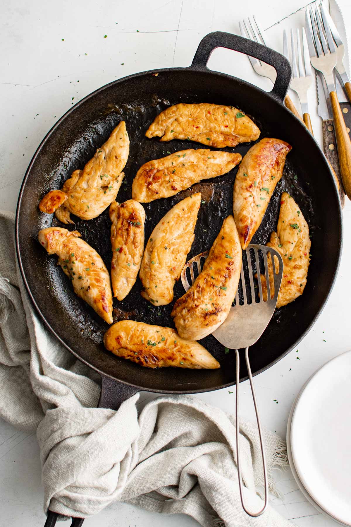 Chicken tenders in a cast iron pan.