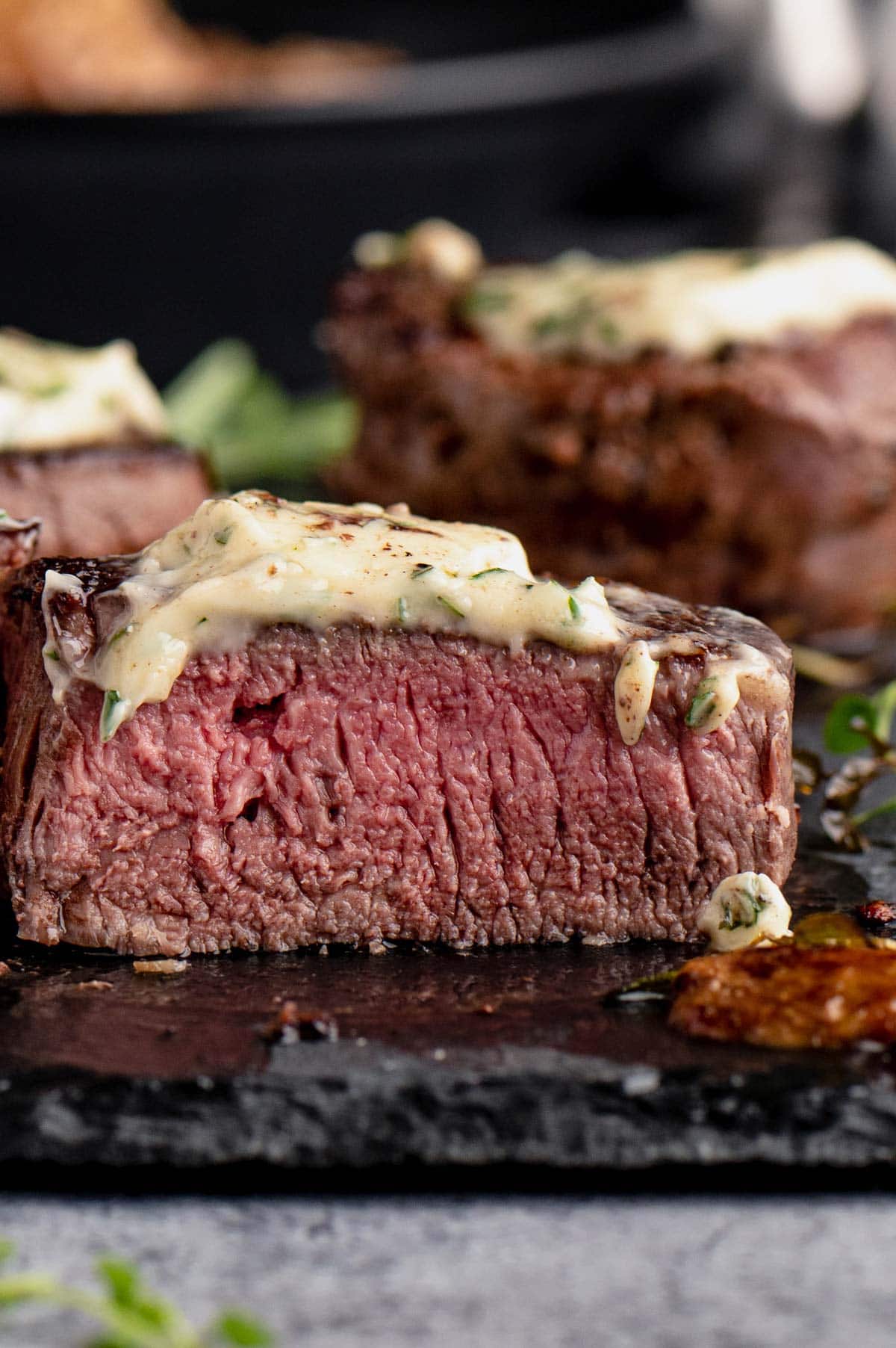 A filet mignon medallion cut open with softened butter on top. 