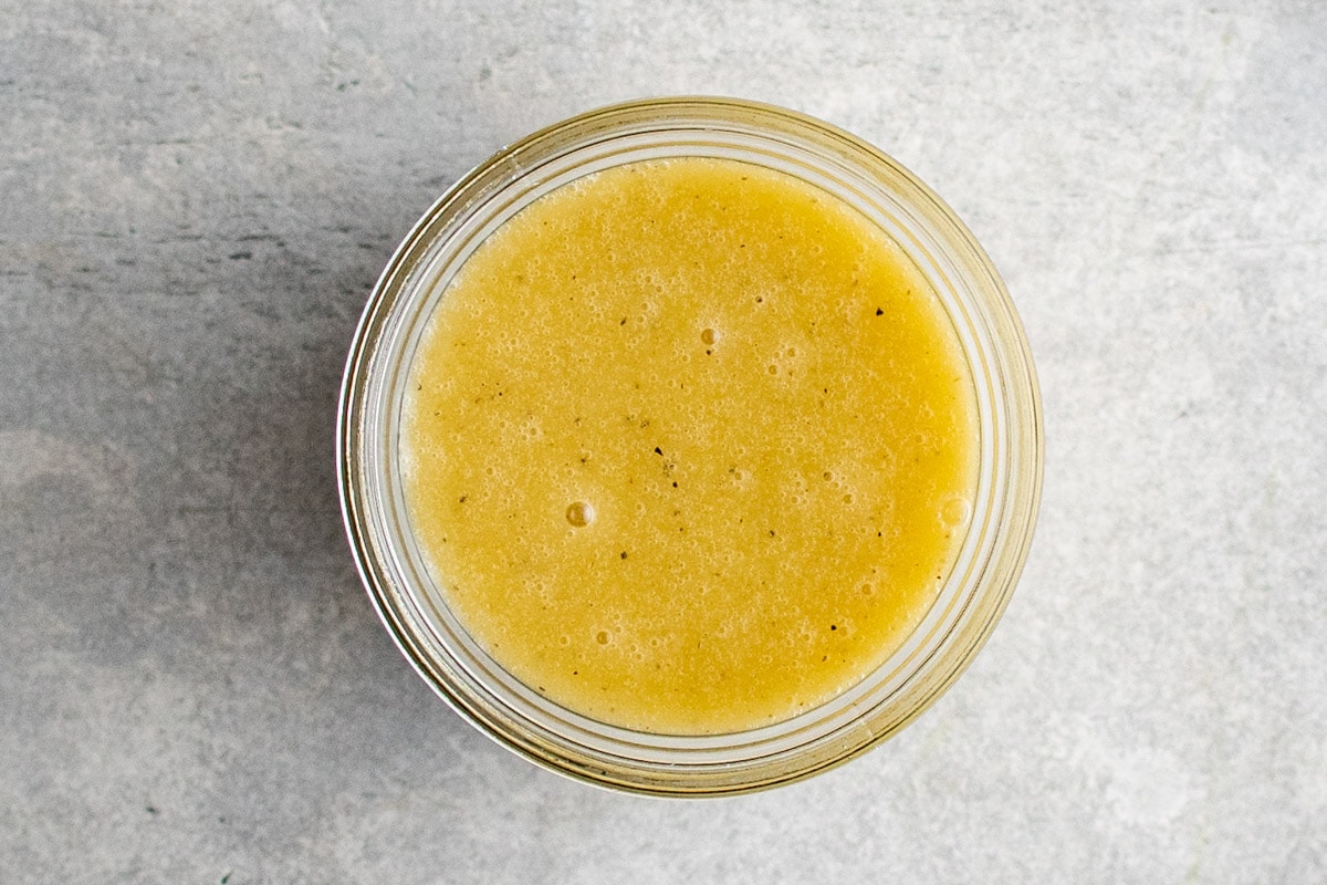 Glass jar filled with champagne vinaigrette.