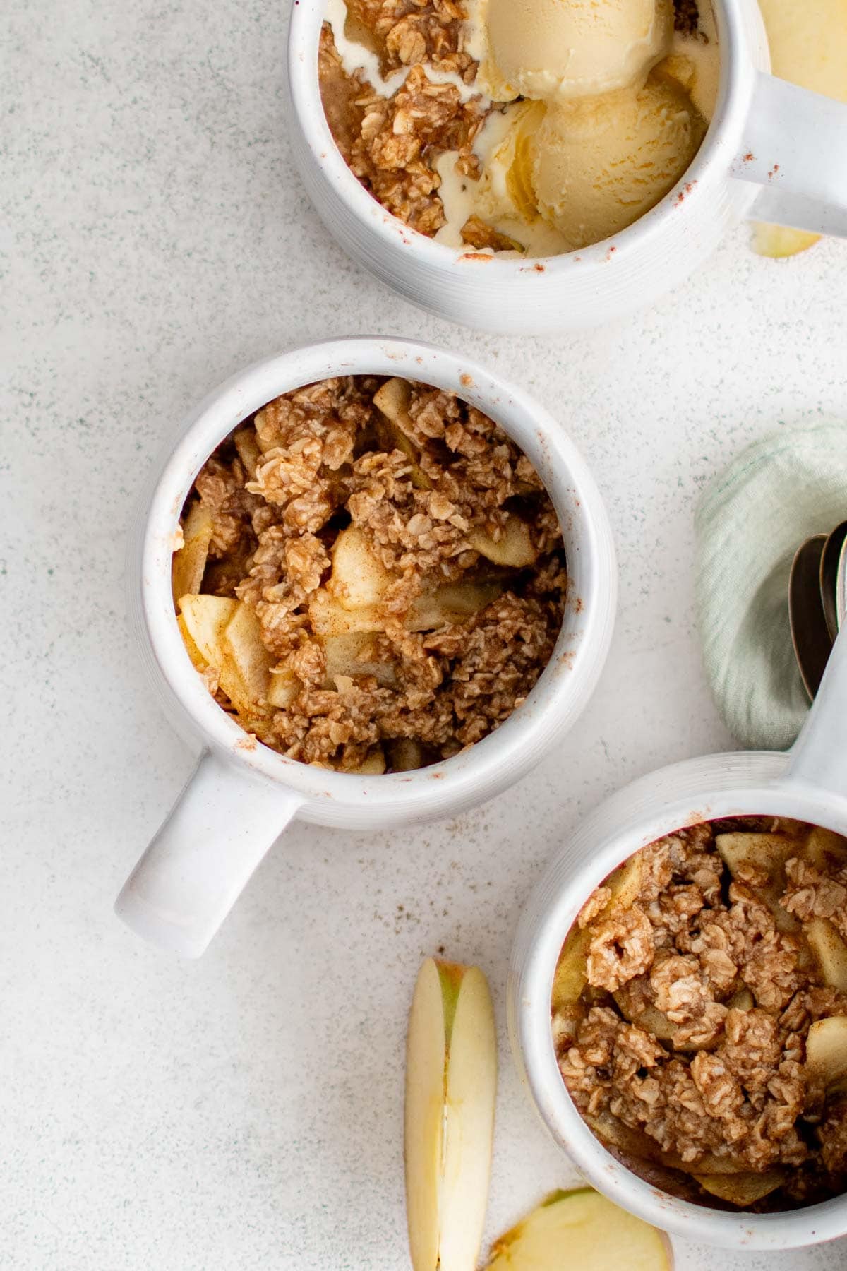 White mugs with crisp topping and sliced apples