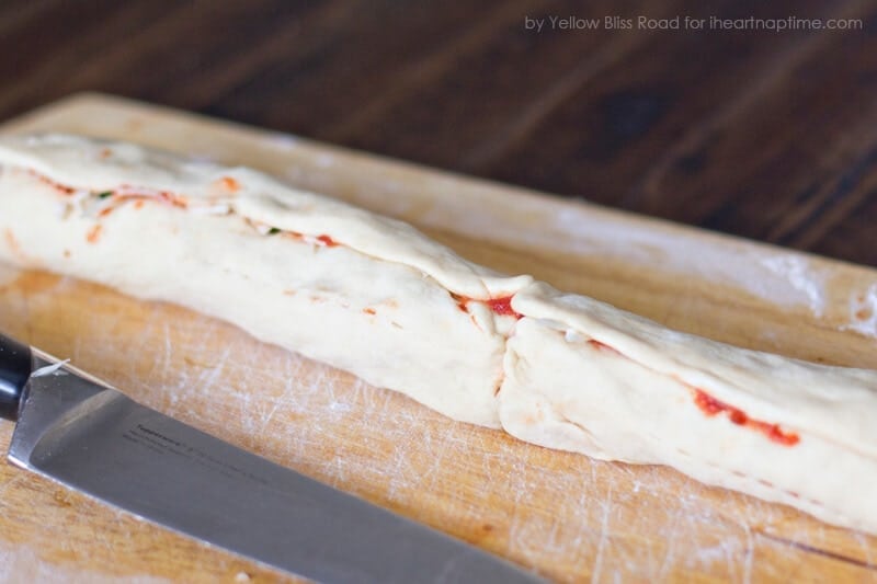 Rolled up crescent dough on a cutting board.