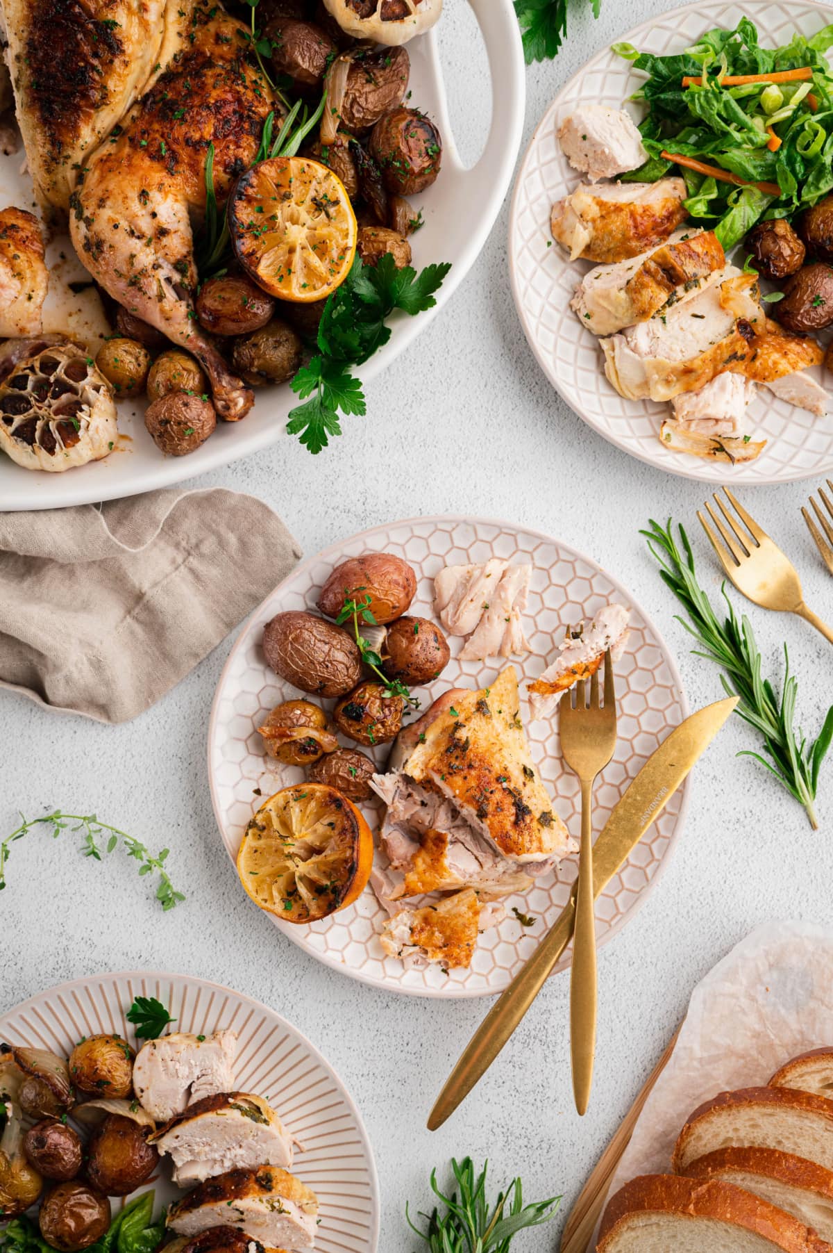 Roasted chicken breast on a plate with potatoes, a fork and a knife.