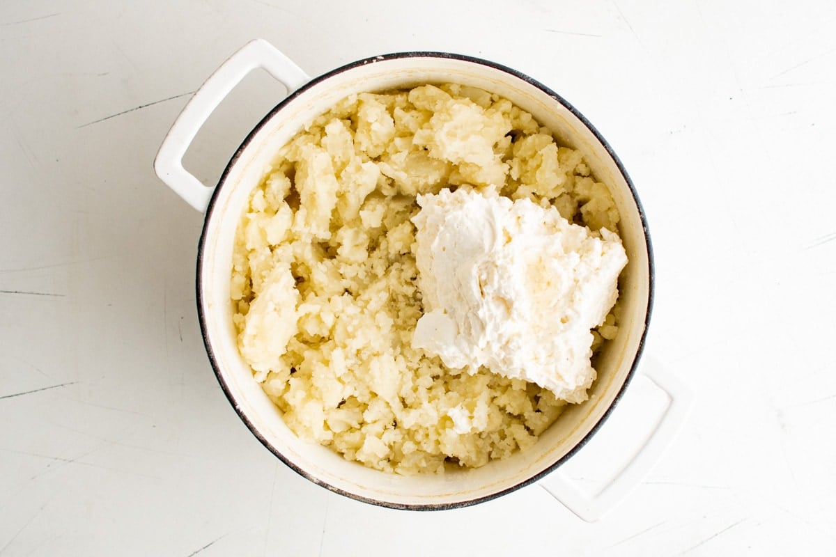 Potatoes and a cheesy mixture in a large pot.