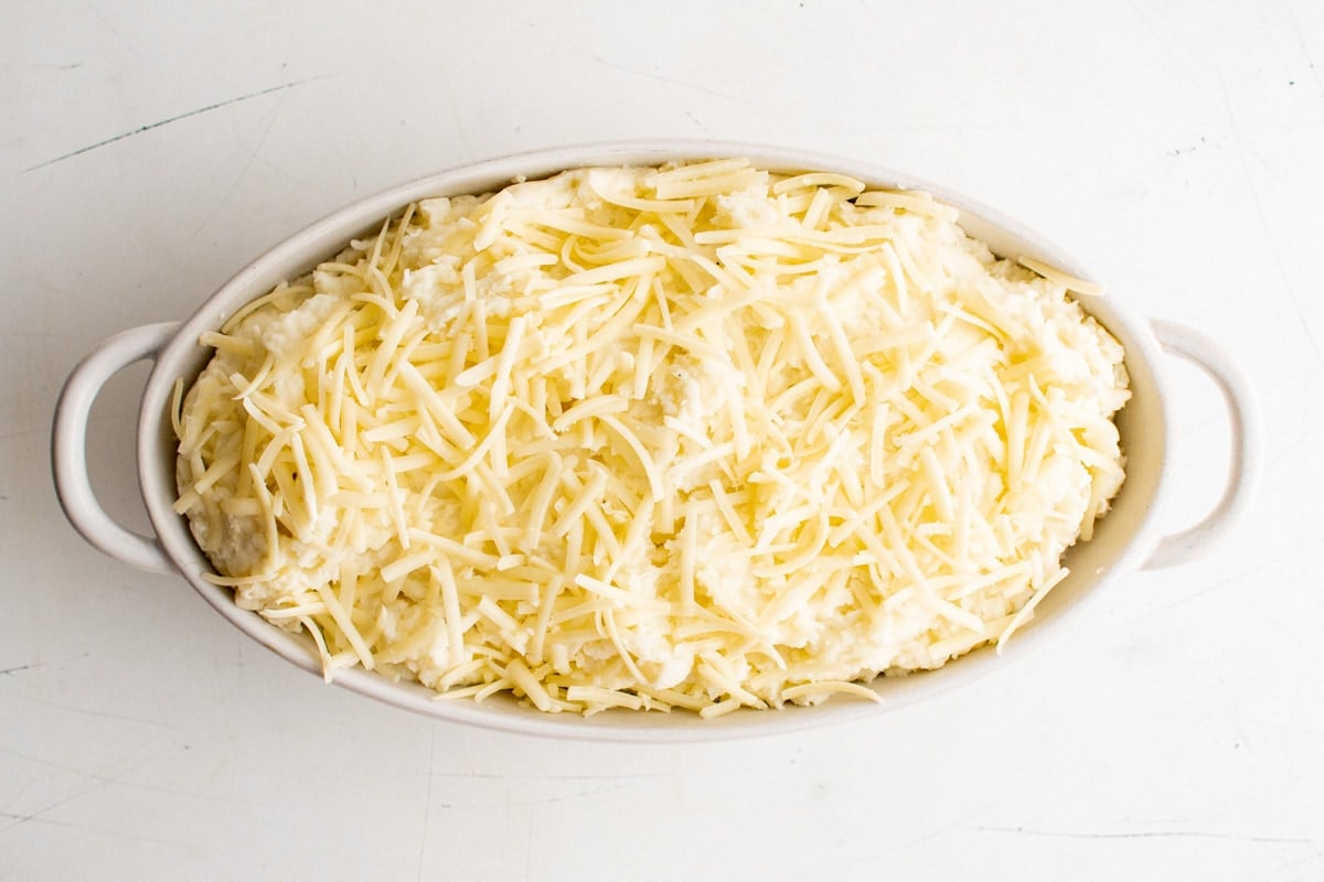 Mashed potaotes with cheese on top in a large casserole dish.