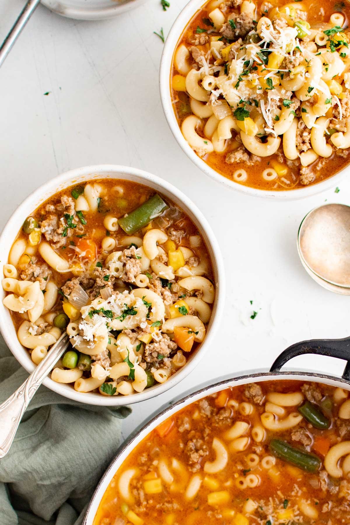 Bowls of hamburger soup with macaroni and vegetables.