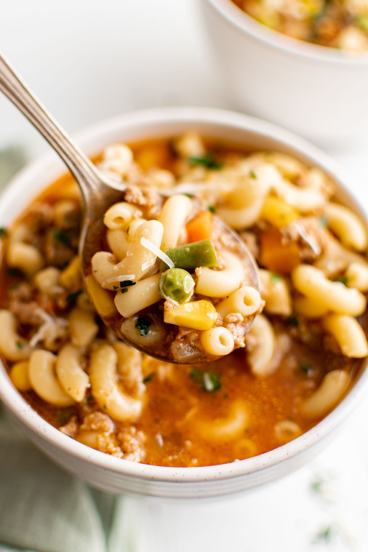 Bowl of hamburger Soup with Macaroni and a spoon.