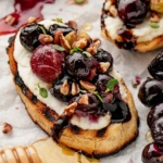 Roasted grapes on a crostini with honey drizzled.