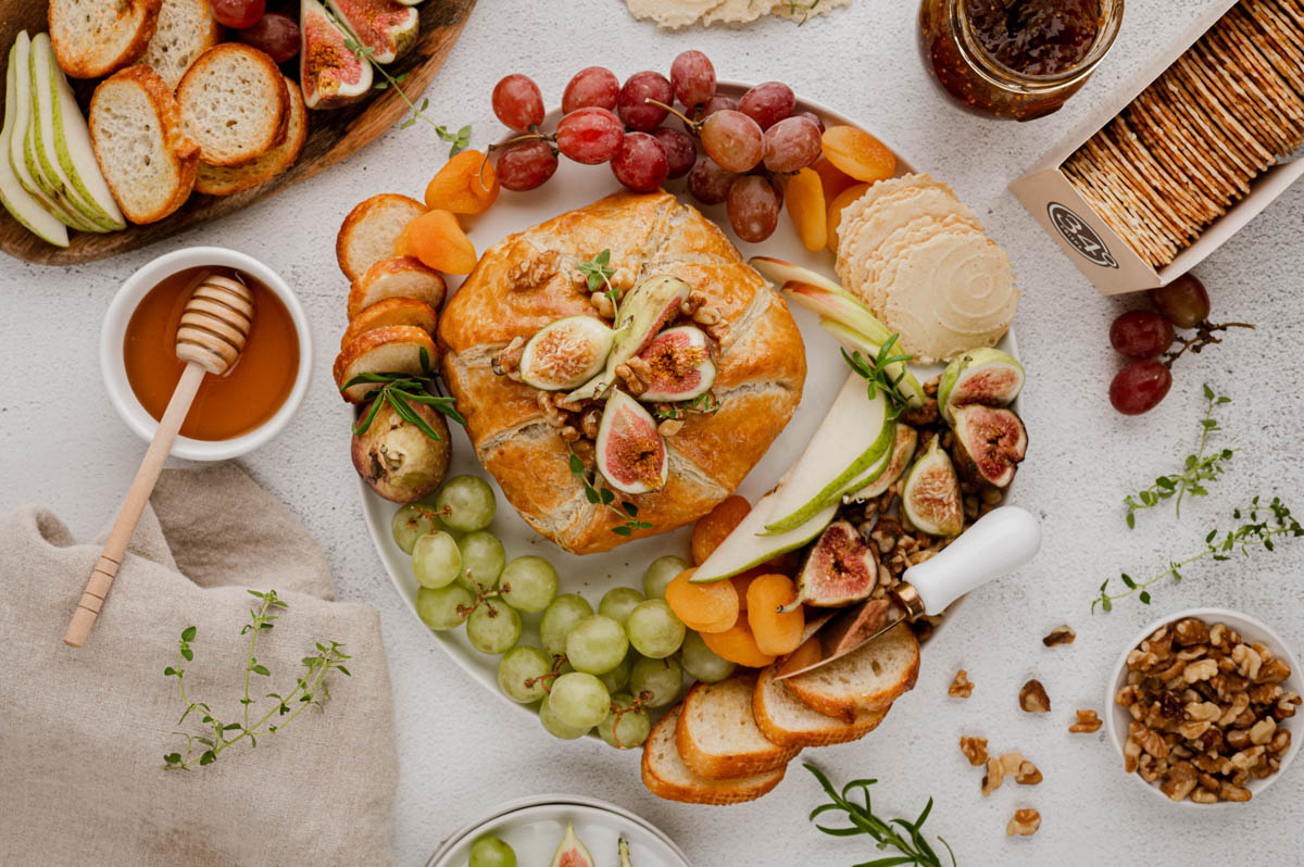 Puff pastry wrapped baked brie with sliced apples, grapes, honey, walnuts, rosemary.