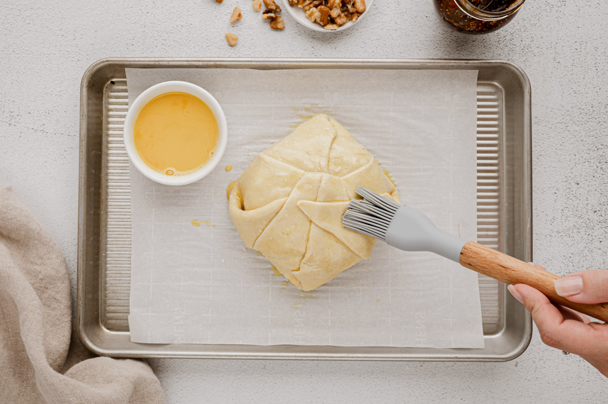 Brushing egg wash over puff pastry.