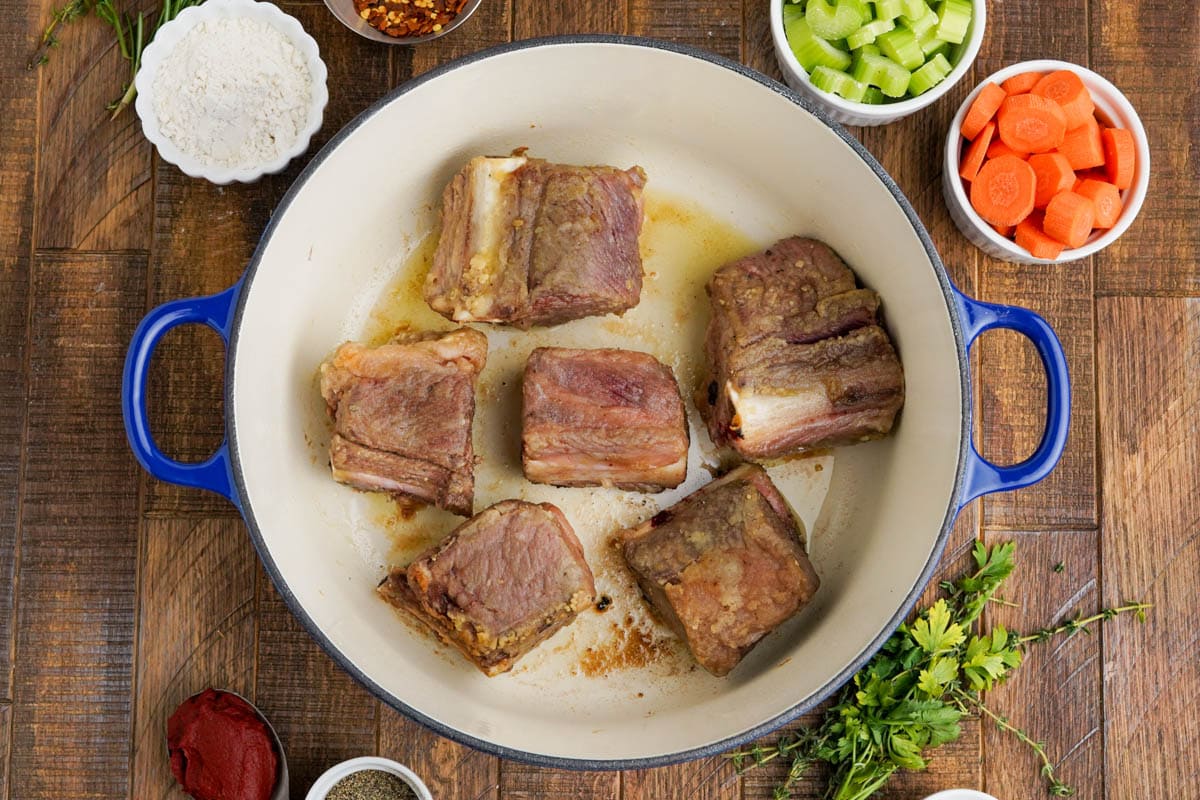 Short ribs, browned, in a dutch oven.