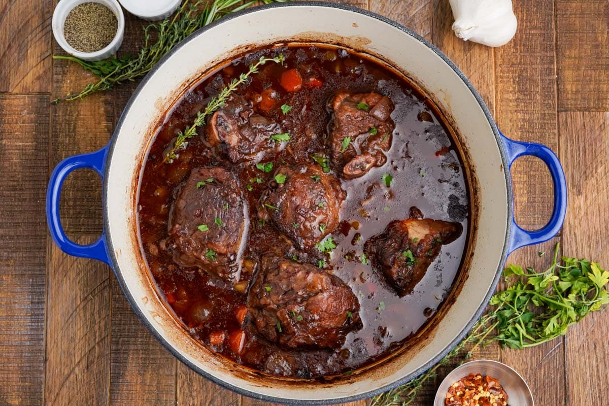 Braised beef short ribs in red wine sauce in a large dutch oven.