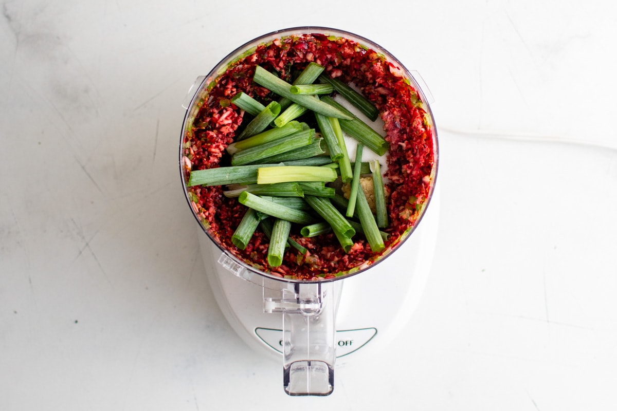 Jalapeno and cranberry salsa in a food processor with green onions.
