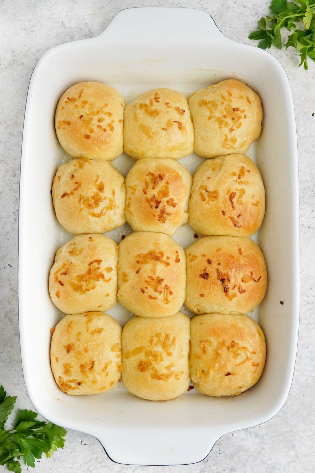 Baked onion rolls in a white baking dish.