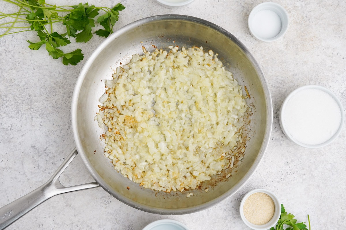 Chopped onions in a skillet, sauteed in oil.