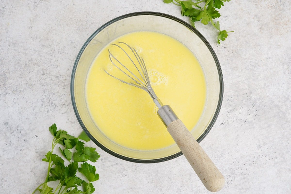 Whisked egg with water in a large mixing bowl.