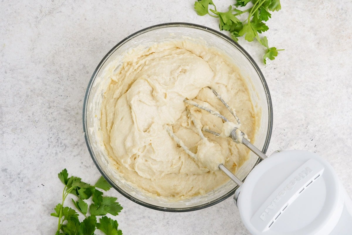 Hand mixer in a bowl of dough.