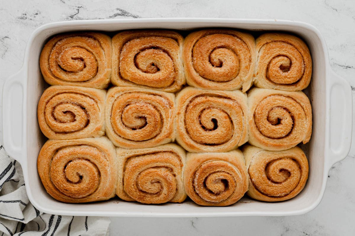 Baked orange rolls in a white baking dish