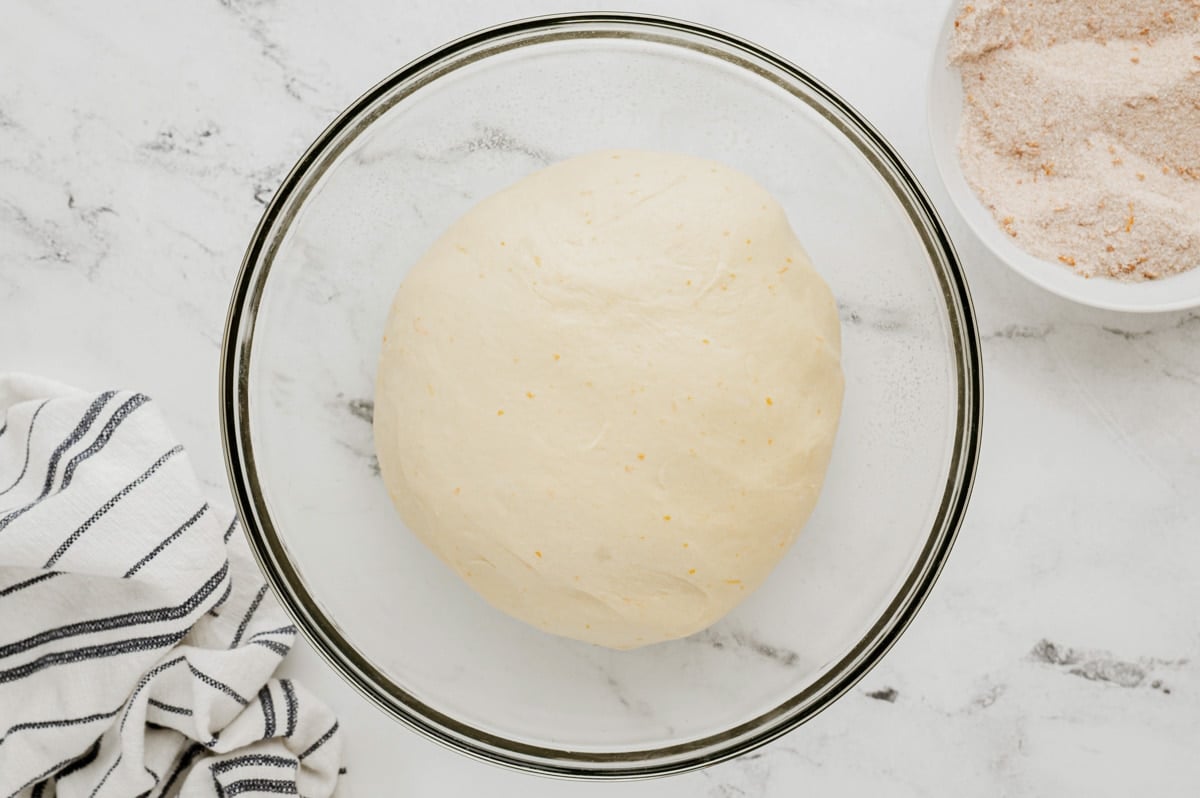 Ball of dough in a clear glass bowl, doubled in size.