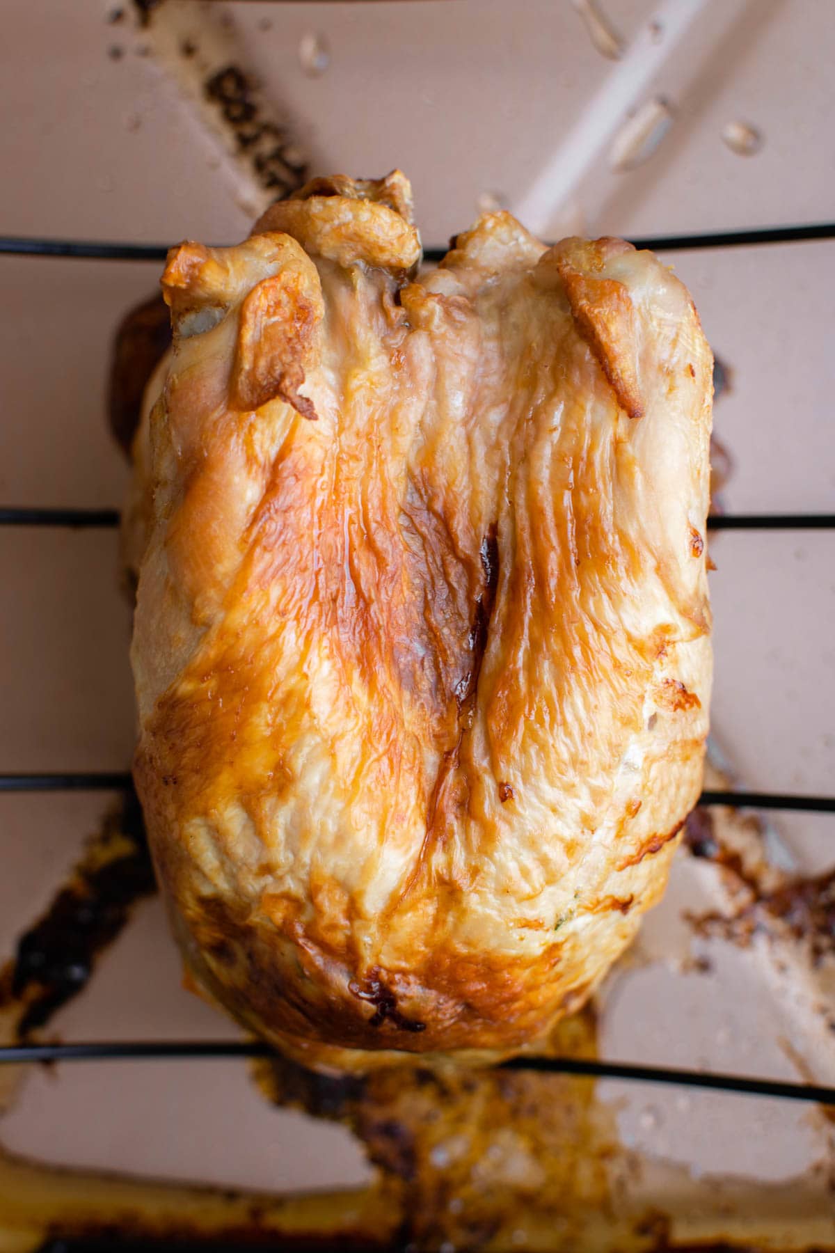 Roast turkey breast on a rack oven a large pan.