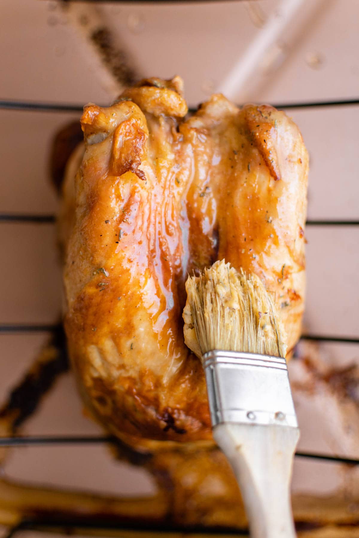 Roasted turkey breast, being brushed with button.