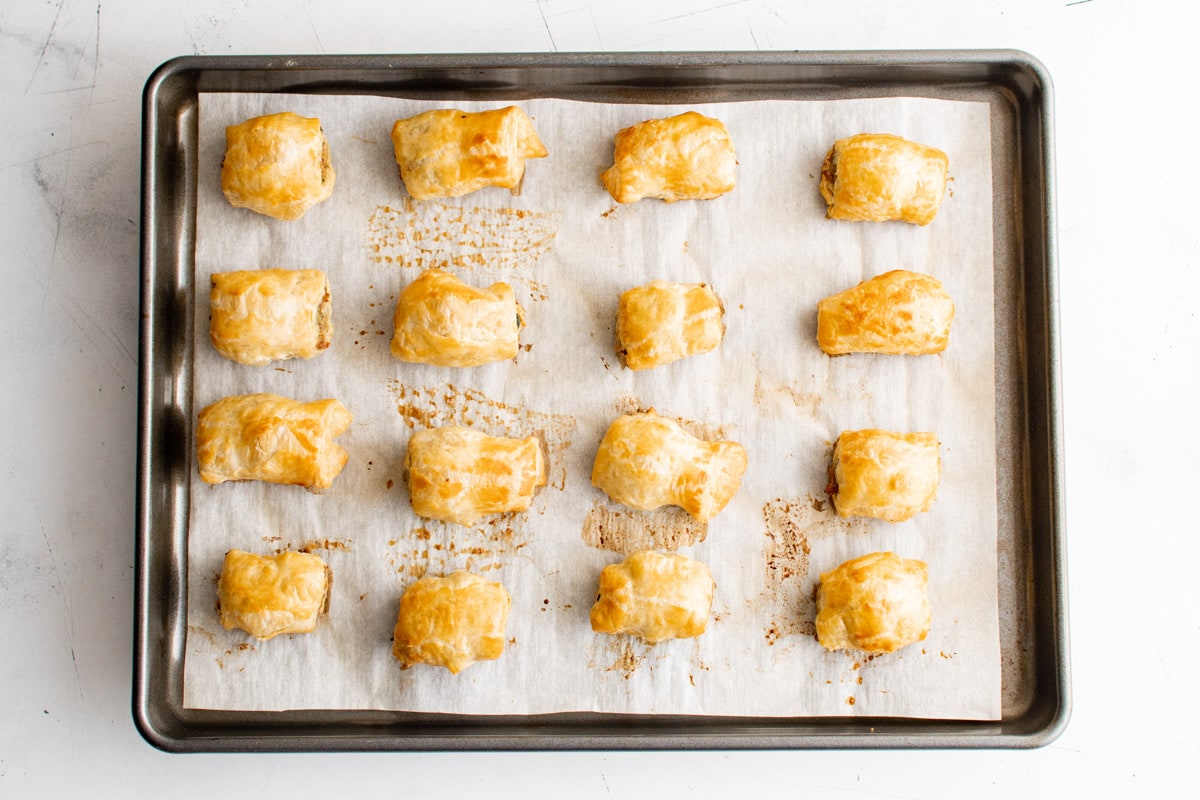 Sausage rolled up in puff pastry on to a baking sheet and baked.