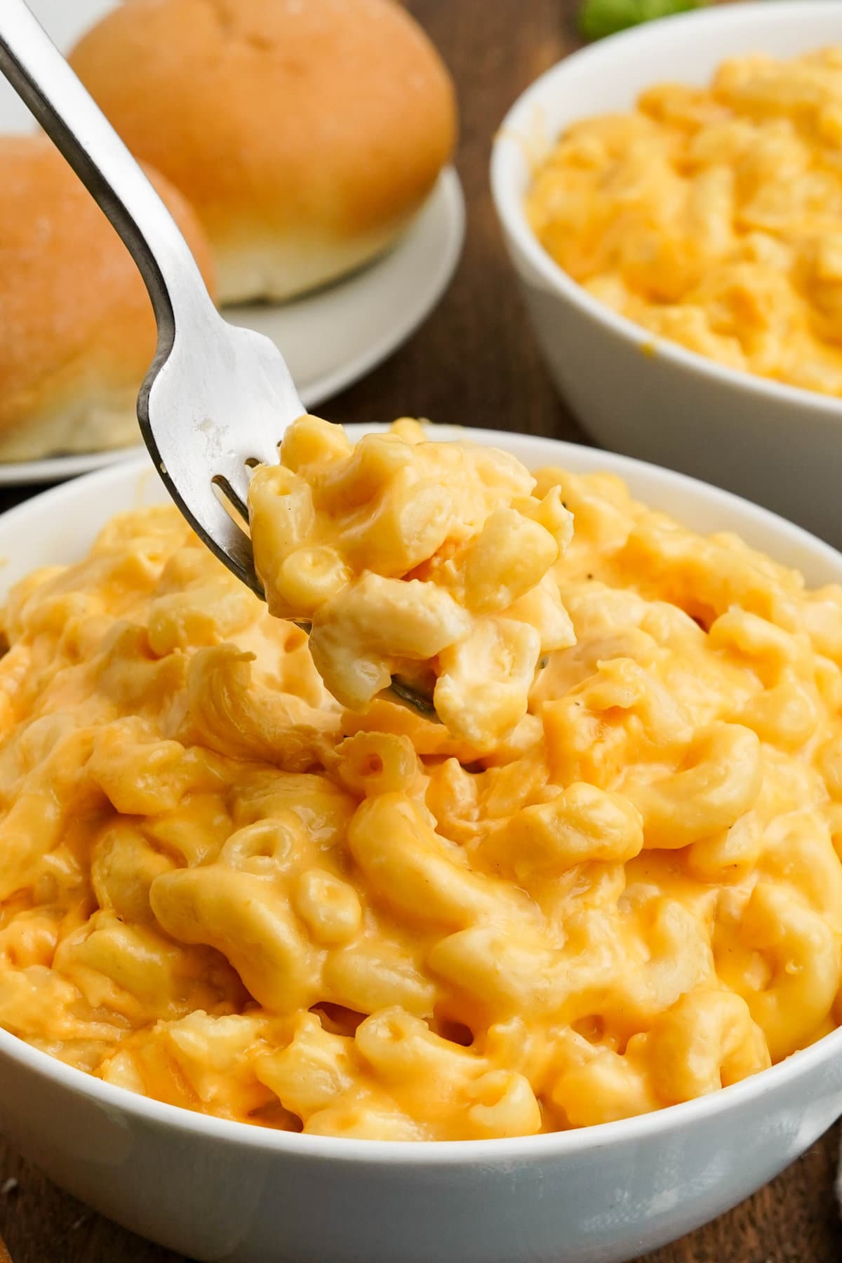 White bowl with mac and cheese and a fork.