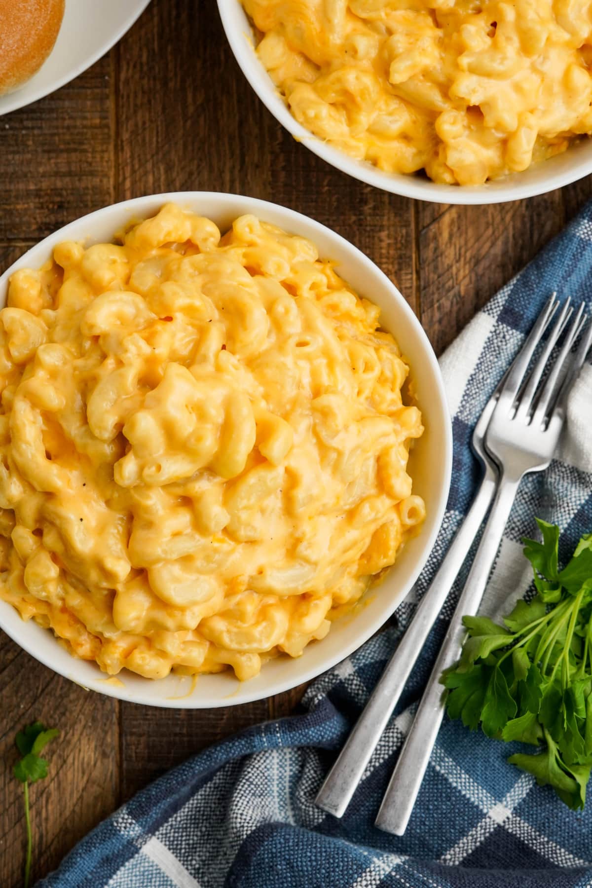 Bowl of mac and cheese with forks and a napkin.