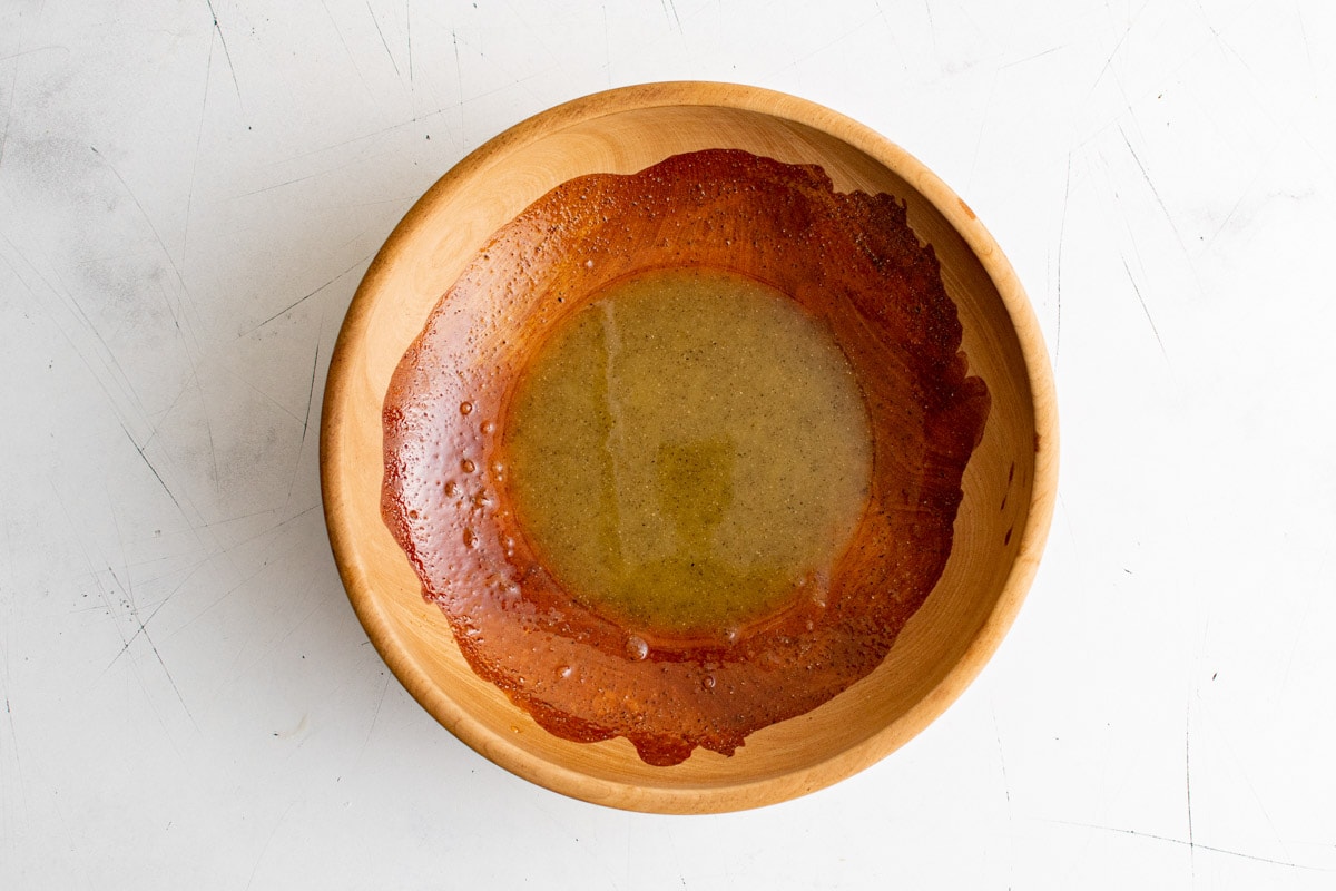 Wood bowl with whisked lemon dressing.