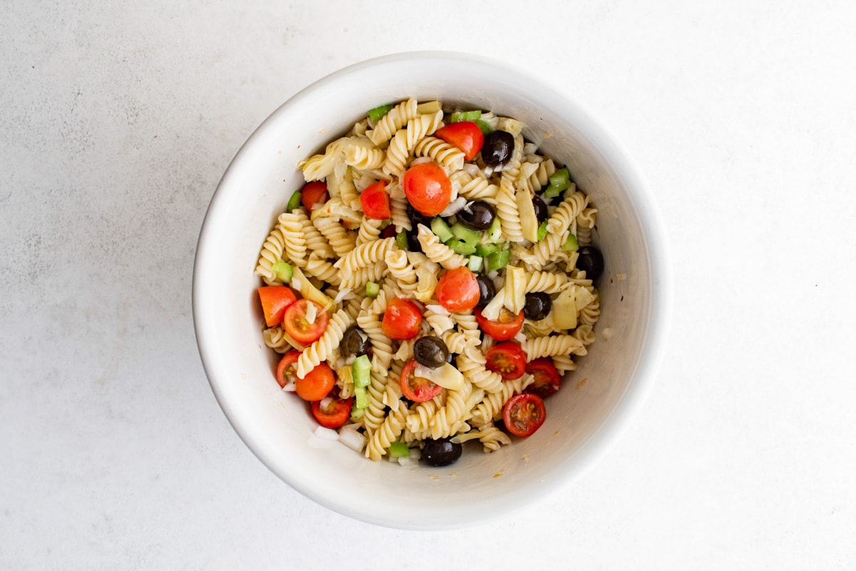 What do you get when you combine all your favorite antipasto ingredients with pasta salad? Antipasto Pasta Salad, your new go-to summer side dish. Prepare to be the most popular person at the picnic! Vegetables and pasta combined in a bowl.