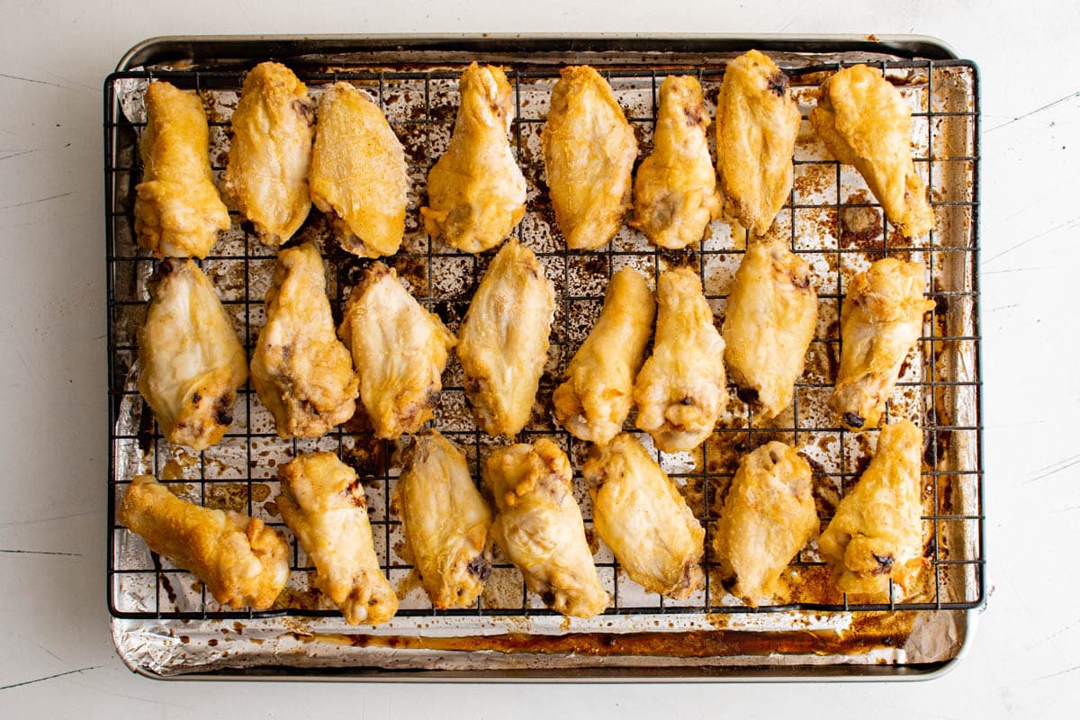 Crispy baked chicken wings on a baking rack over a baking sheet.