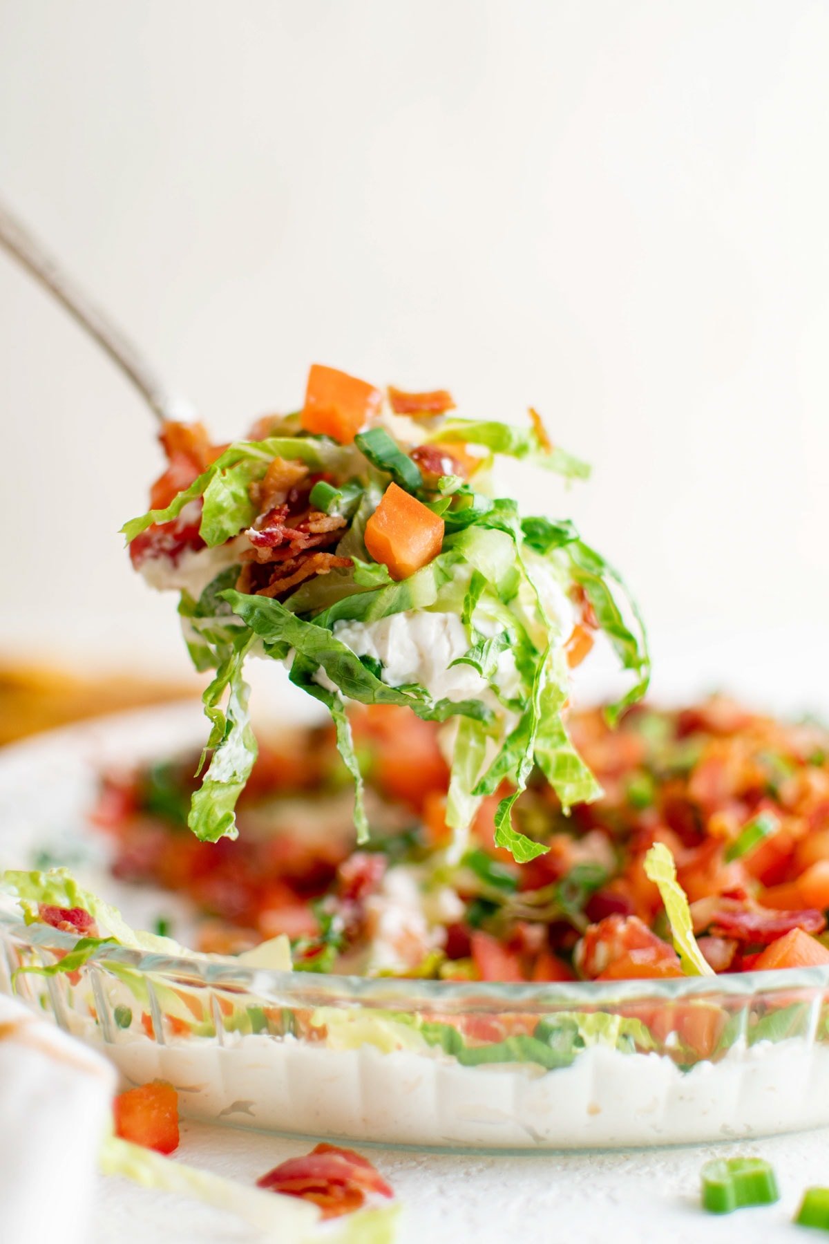 A spoon holding a serving os blt dip.