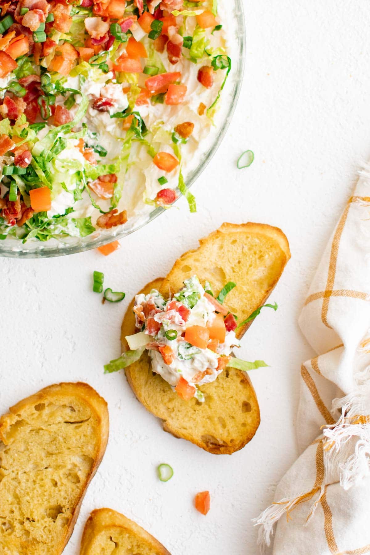BLT Dip with Crostini for dipping | appetizer | Cold dip | Game day food Toasted bread with blt dip scooped on it.