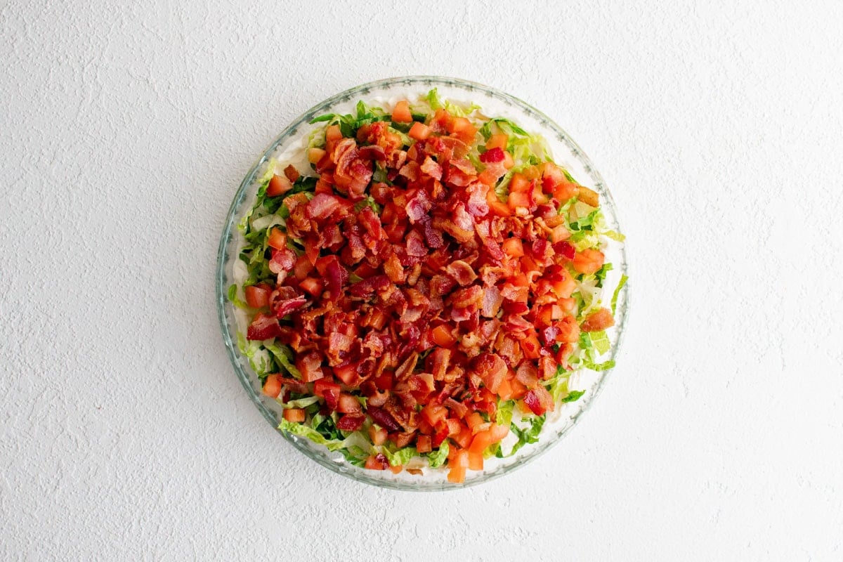 Cream cheese and mayo dip topped with shredded lettuce, diced tomatoes and chopped bacon.