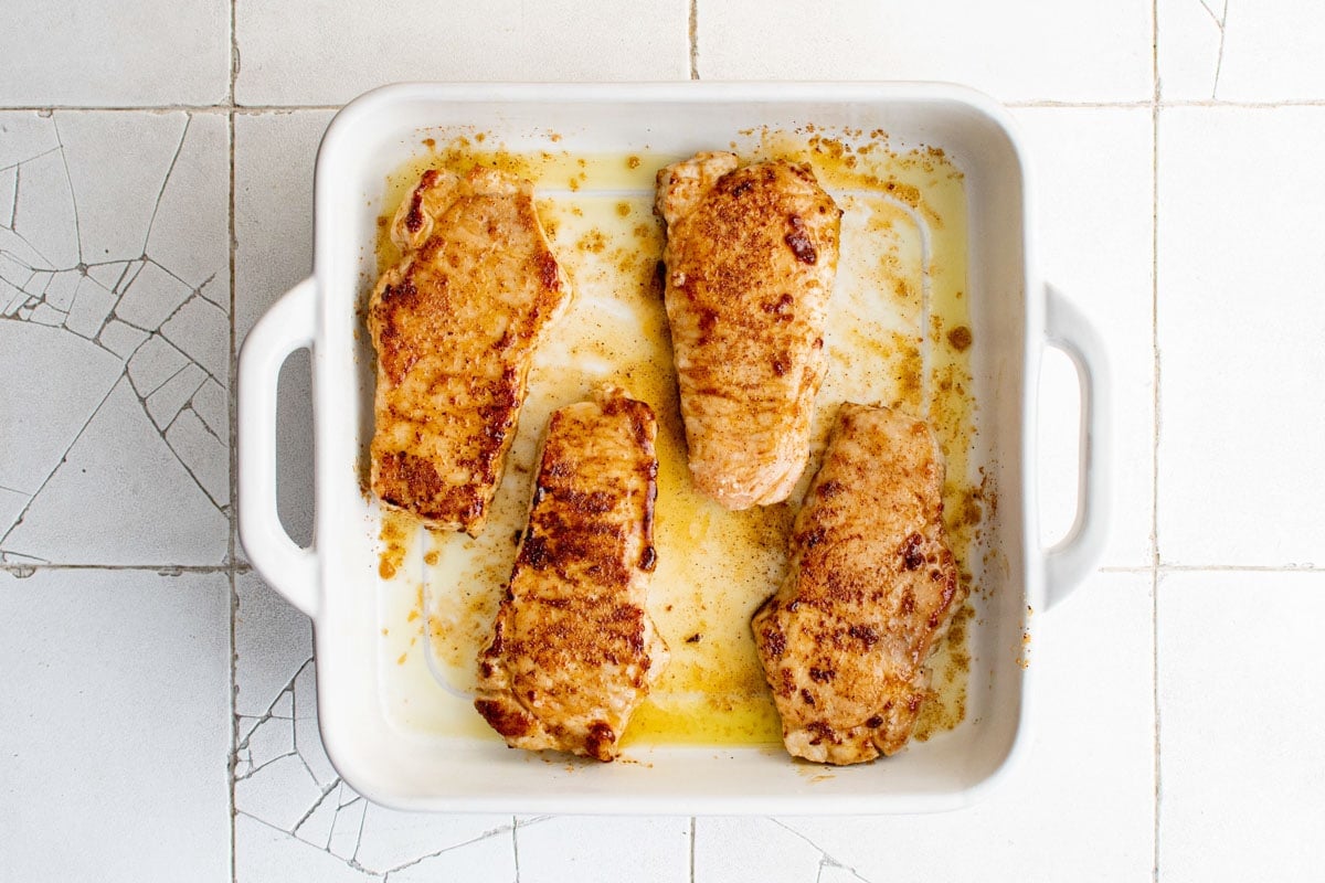 Baked pork chops in a baking dish.