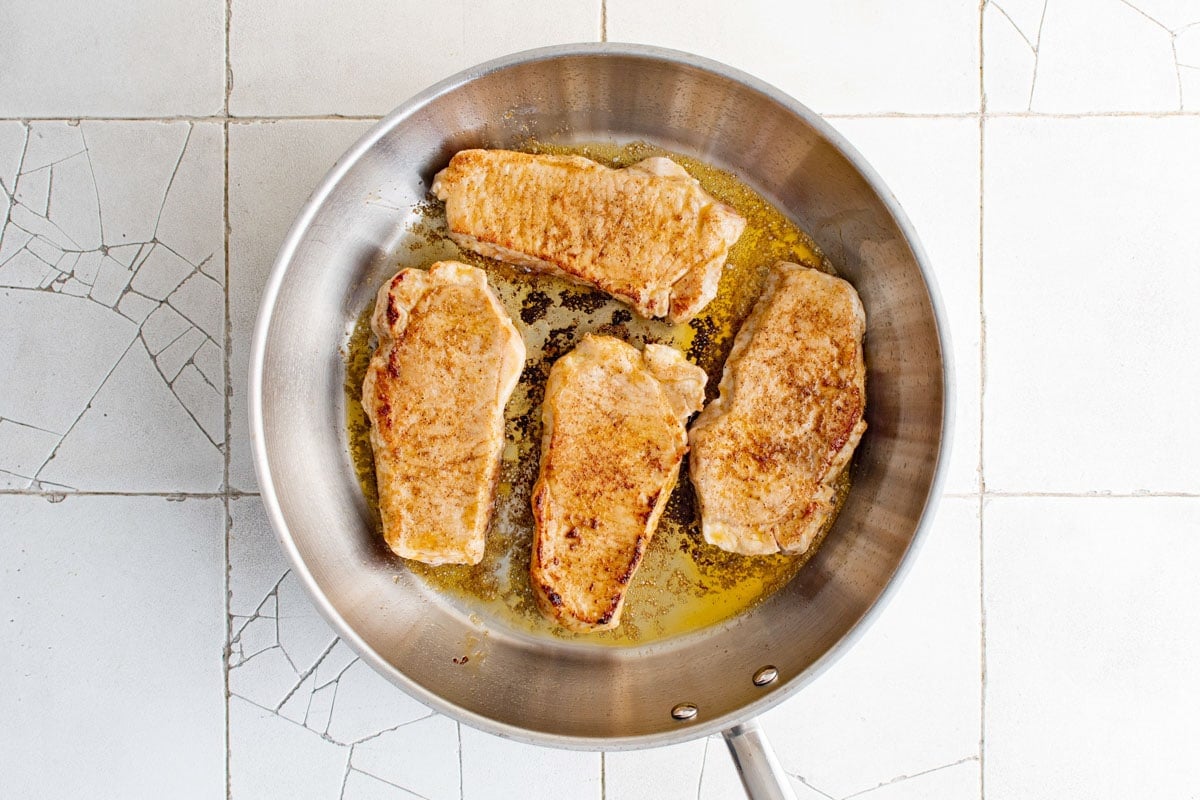 Seared pork chops in a skillet. 