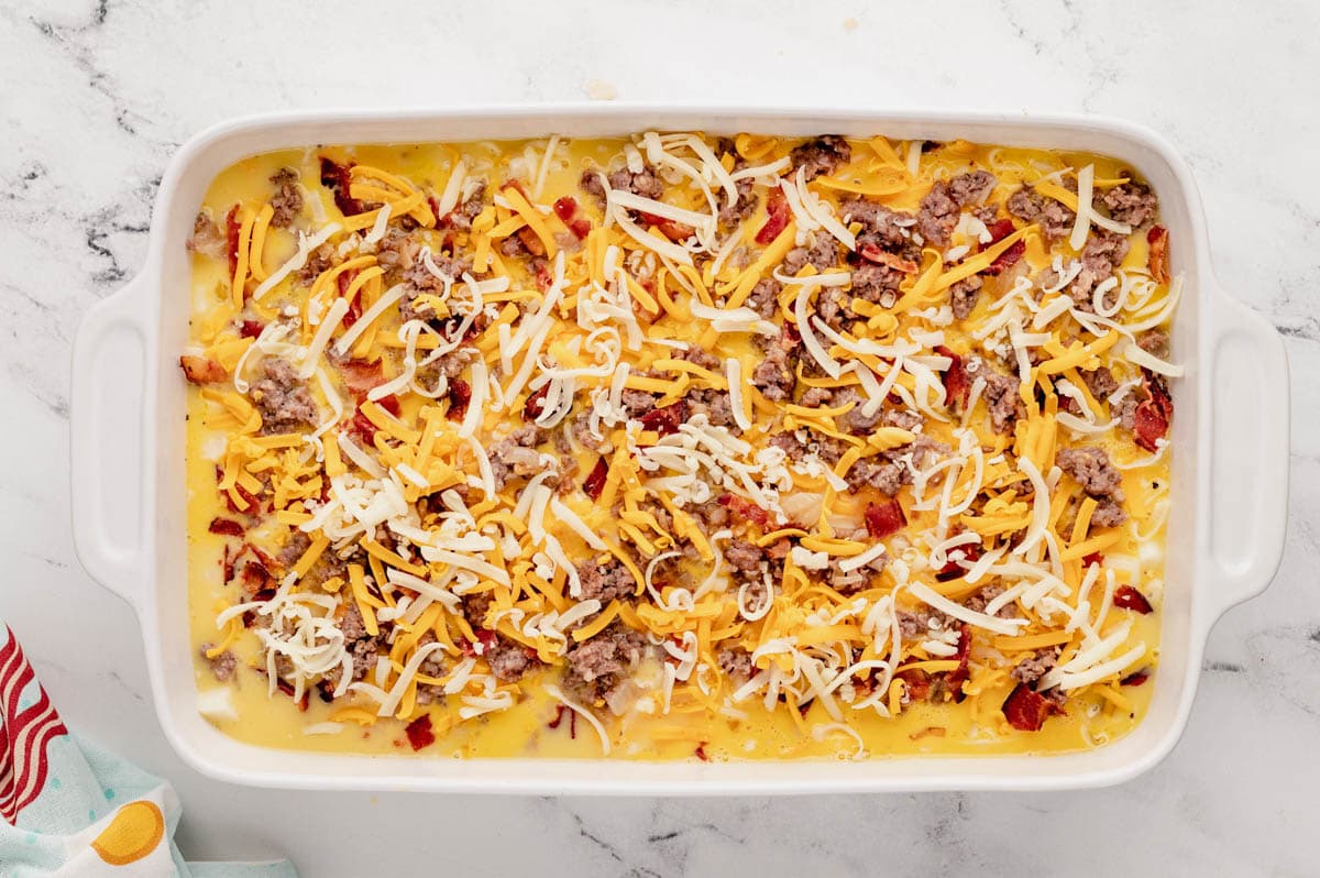 Unbaked breakfast casserole in a baking dish.