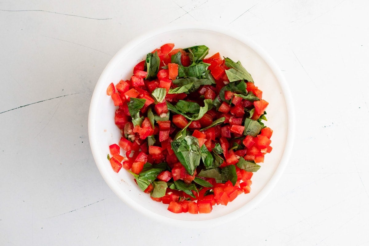 Diced tomato and basil in a bowl.