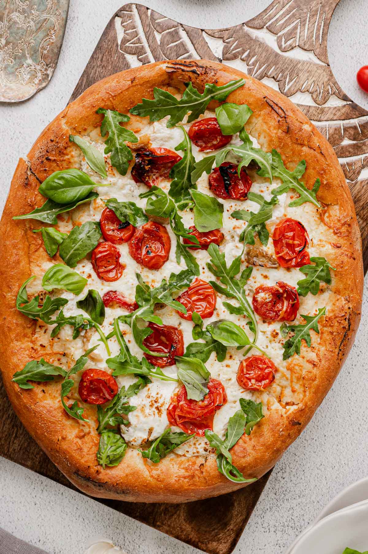 Burrata Pizza with tomatoes, arugula and basil.