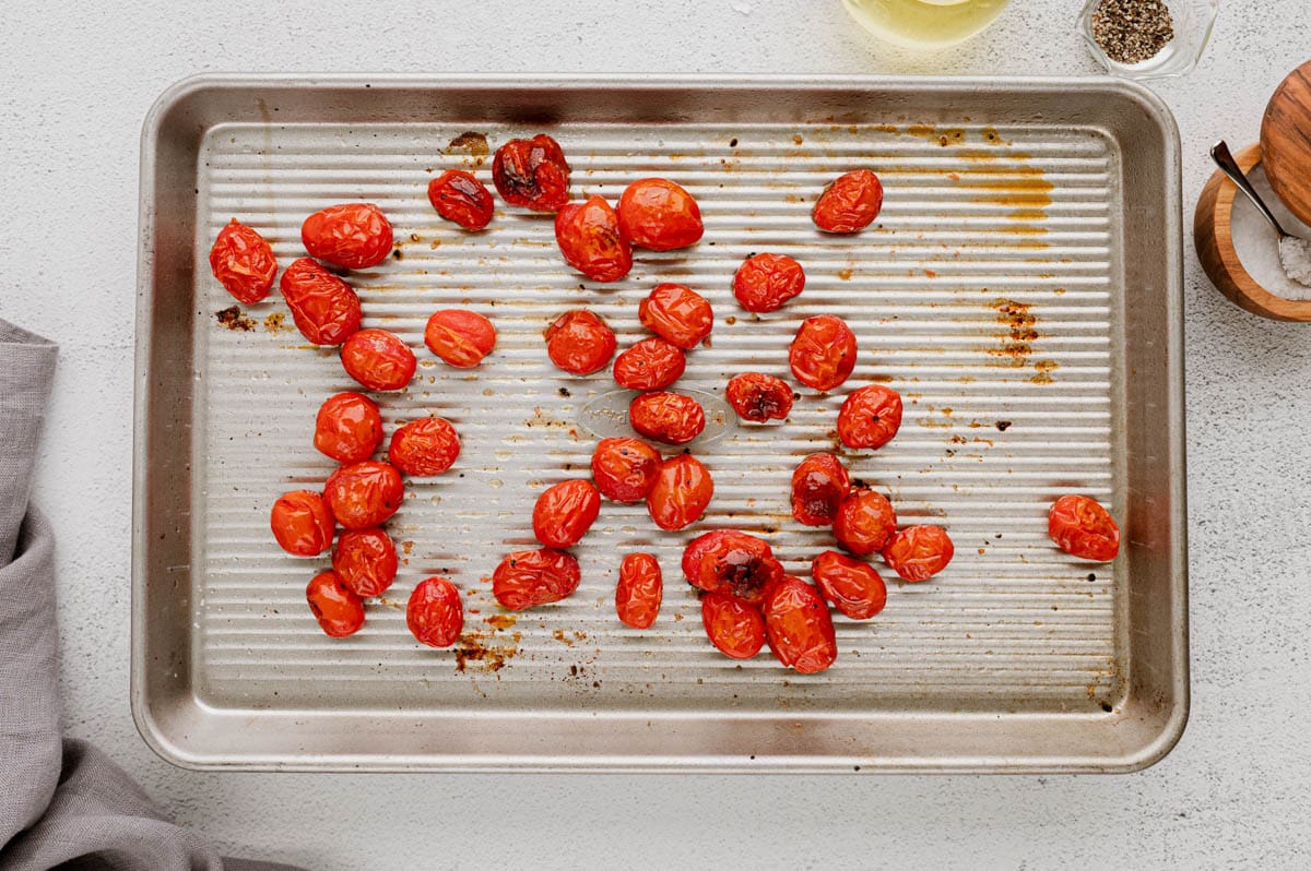 Roasted cherry tomatoes on a sheet pan.