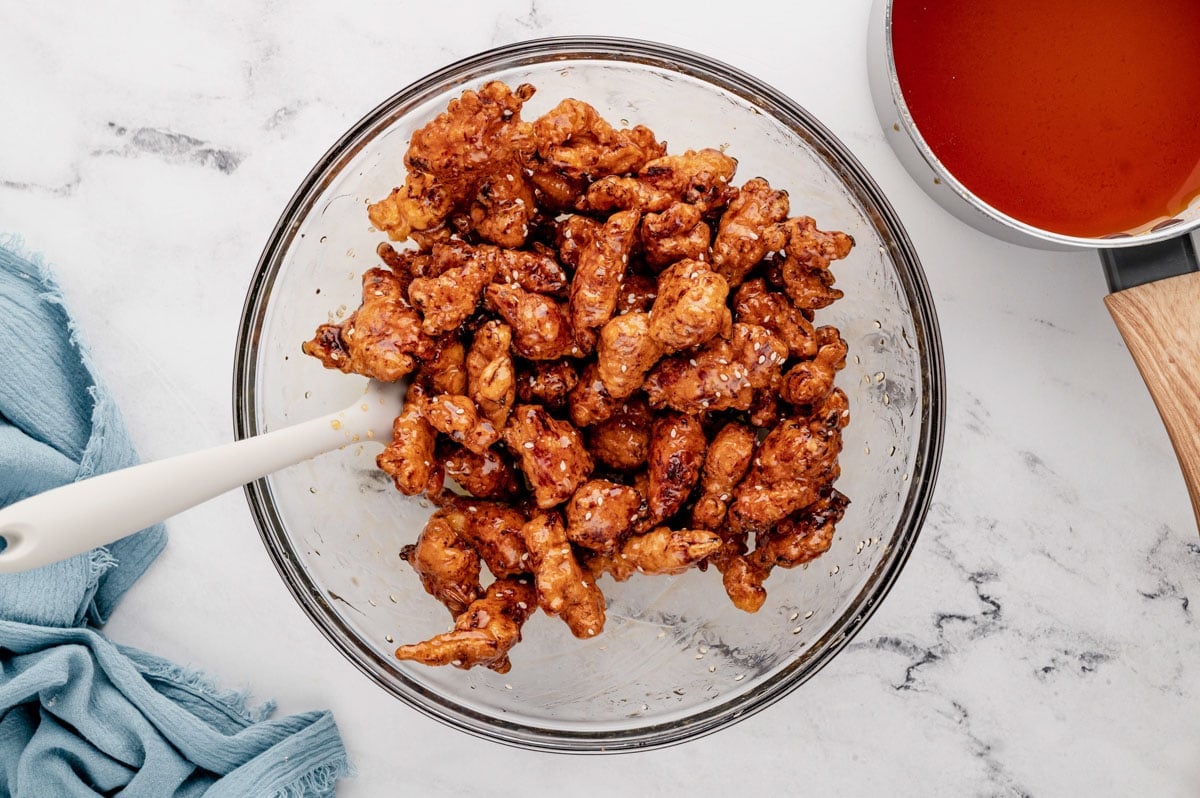 Fried chicken pieces in a large bowl, coated in honey sauce.