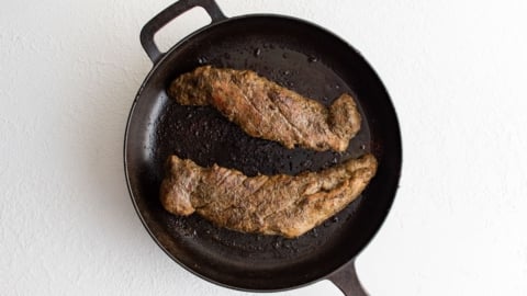 Seared and roasted pork tenderloins in a skillet.