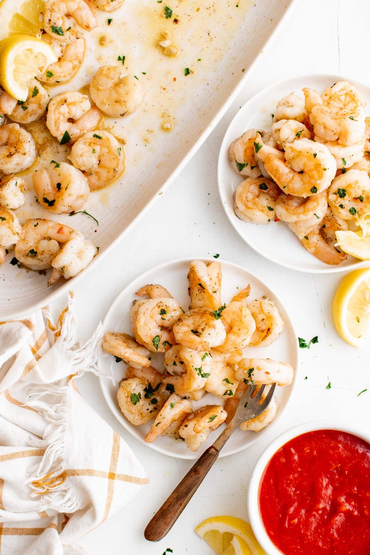 Served shrimp on small plates with forks and cocktail sauce..