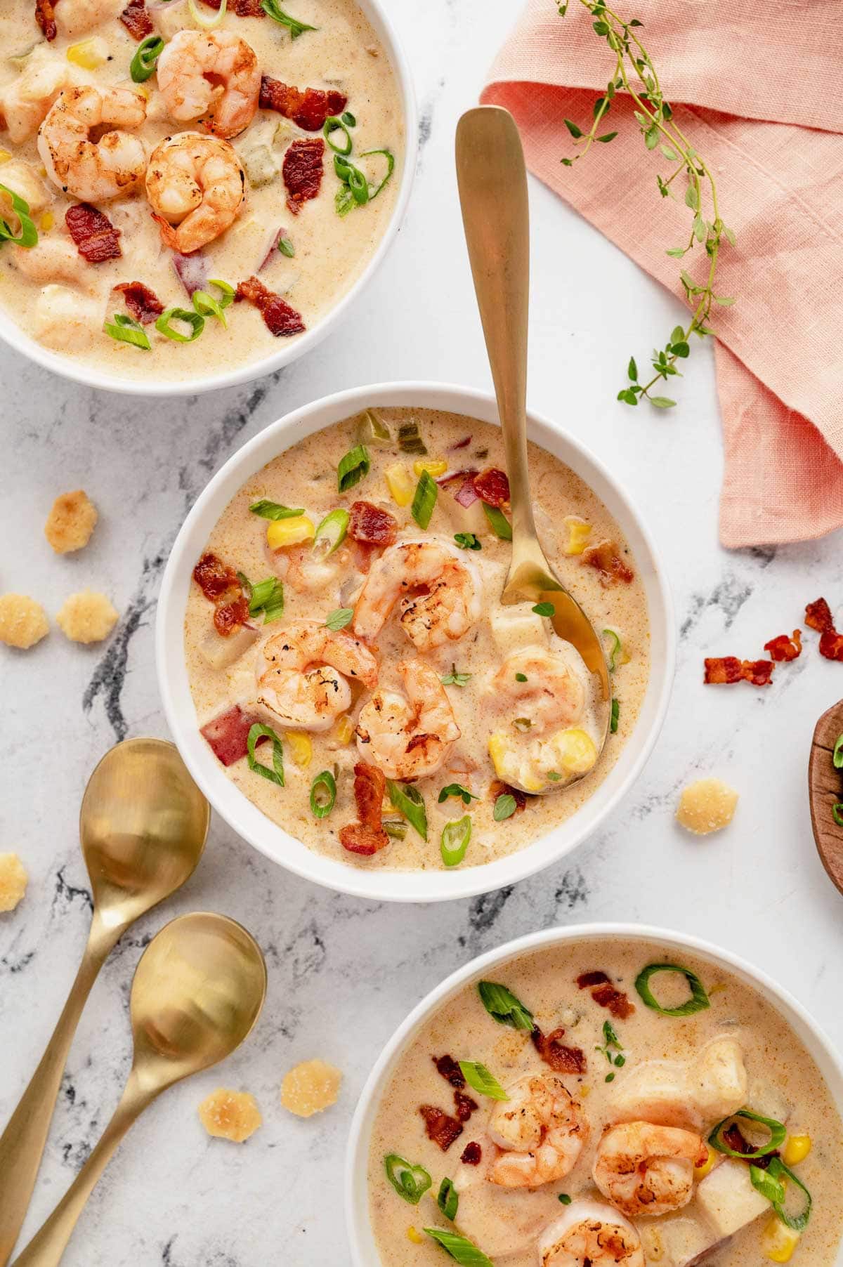 Shrimp corn chowder in a white bowl with a spoon.