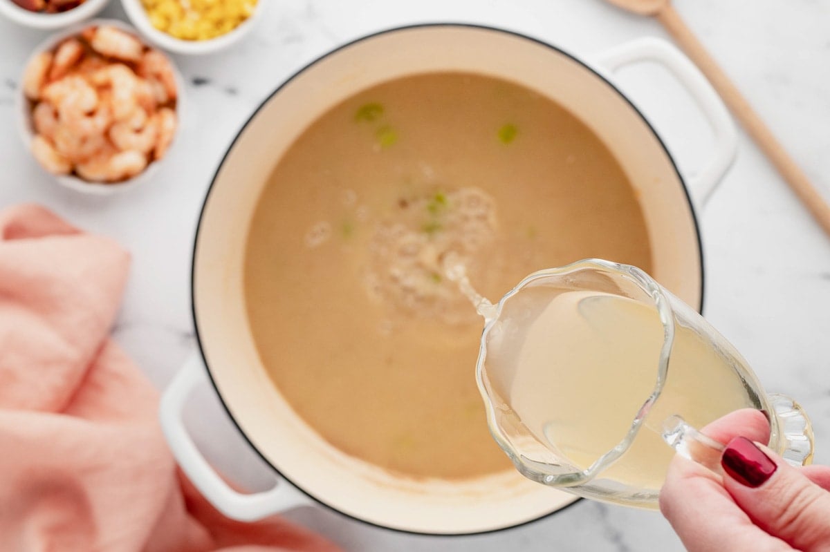 Creamy broth pouring into a large pot.